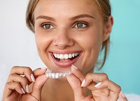 A woman using a take-home teeth whitening tray