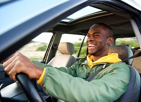 Man smiles while driving
