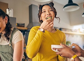 Woman in yellow shirt eating with friends