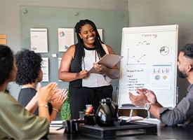 Woman smiling while giving presentation at work