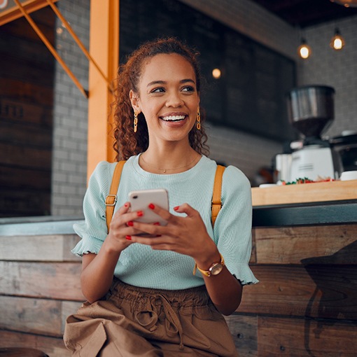 Smiling woman sitting on barstool at restaurant