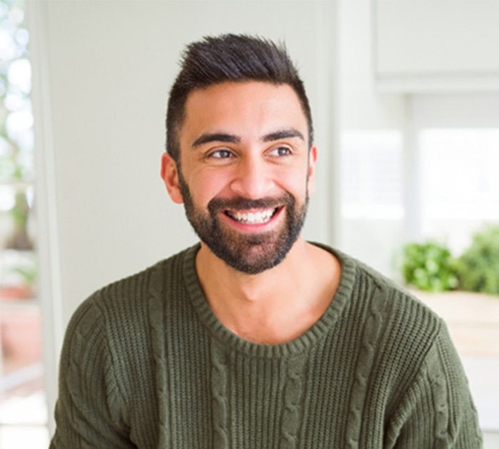 Man in green sweater smiling