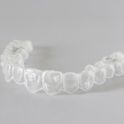 Clear aligner lying on grey surface