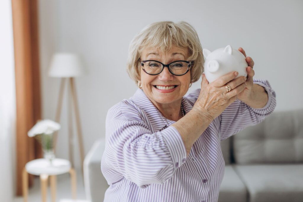 A woman holding a piggy bank and smiling.